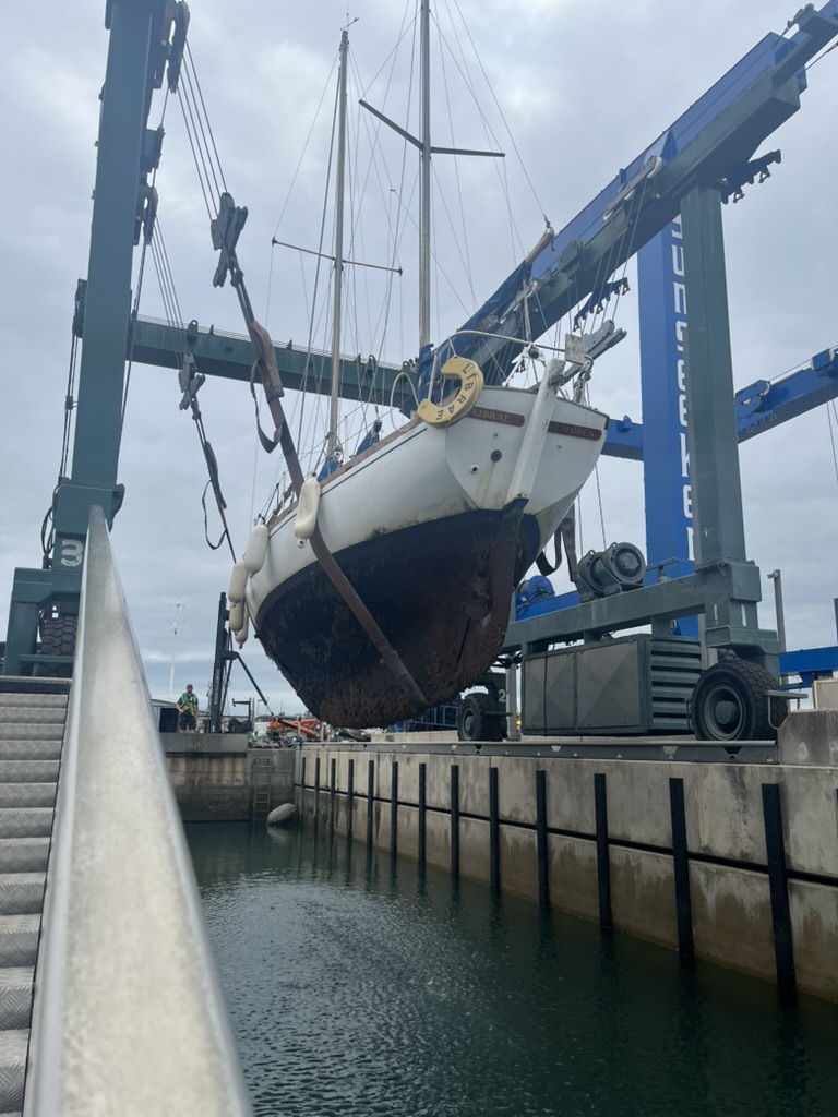 Before: hauled out in the boat lift, hull caked in growth below the waterline