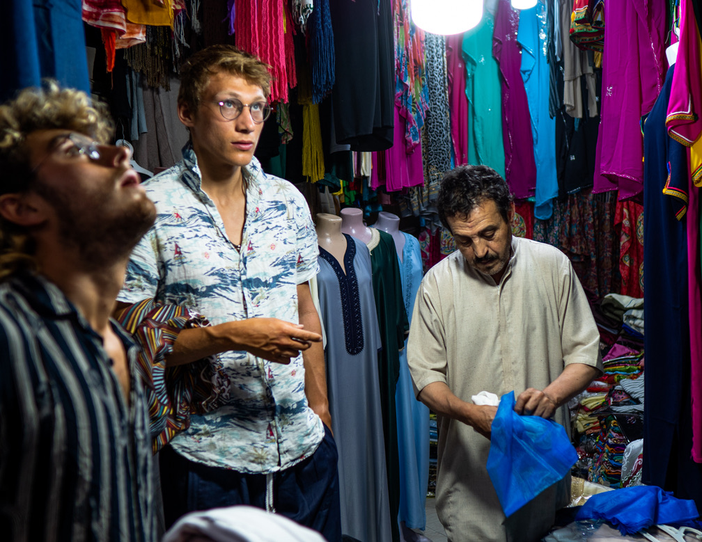Browsing a colourful clothing stall in a busy souk